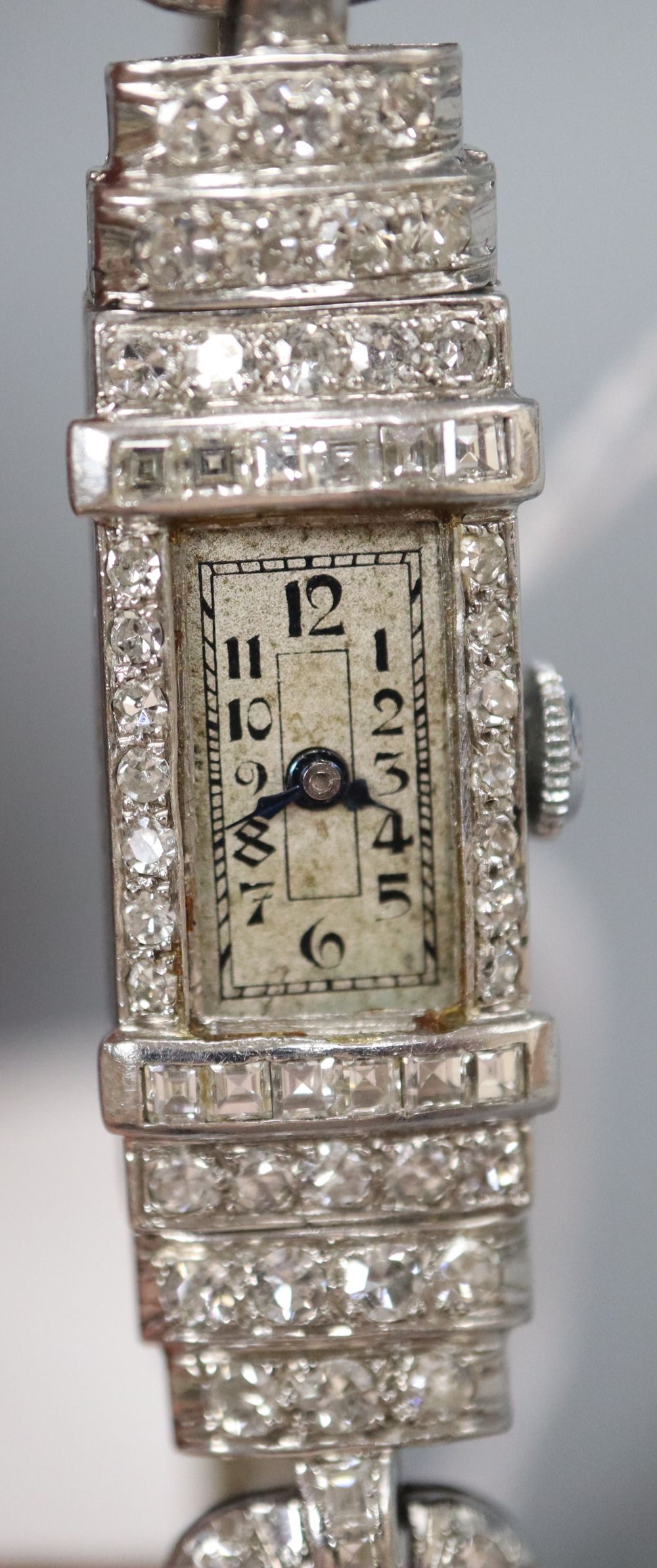 A ladys Art Deco white metal (stamped platinum) and diamond set cocktail watch, with fabric strap, 16.7cm, gross 16.1 grams.